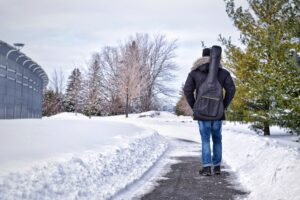 Canadian immigrant walking on snowy sidewalk. One thing to consider when moving to Canada.